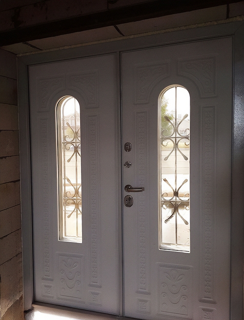 Двустворчатая белая дверь с ковкой